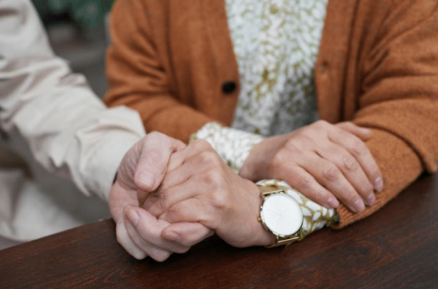 Photo of two people holding hands.