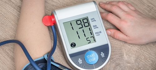 Close up photo of someone taking their blood pressure using a digital machine.