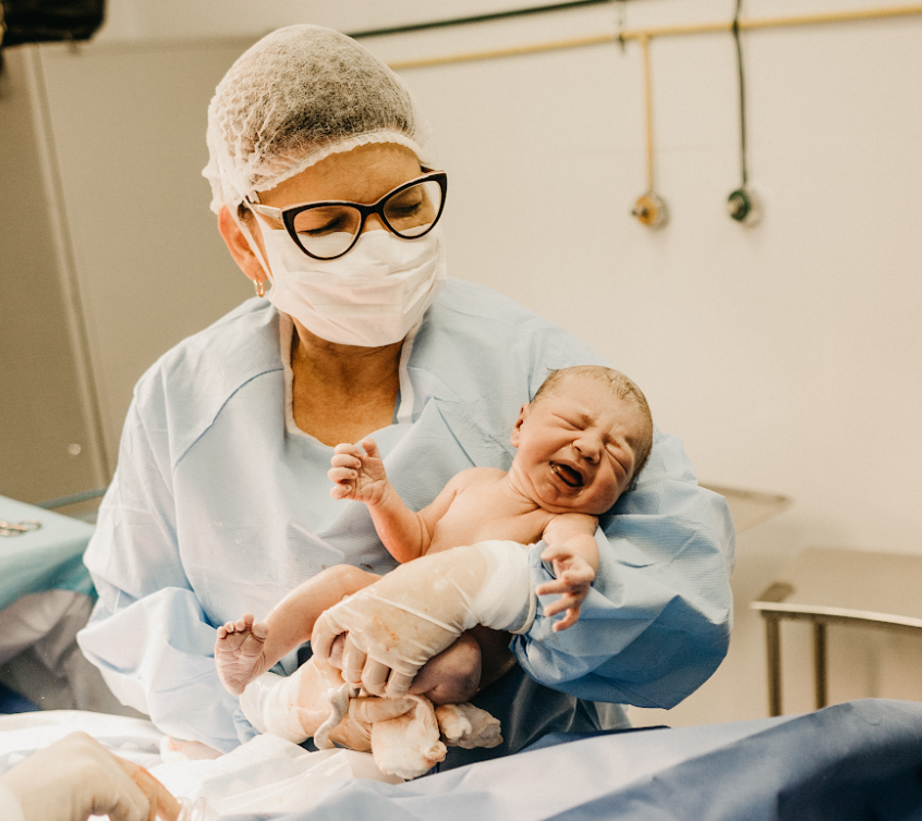 Picture of a nurse holding a baby born by caesarean.