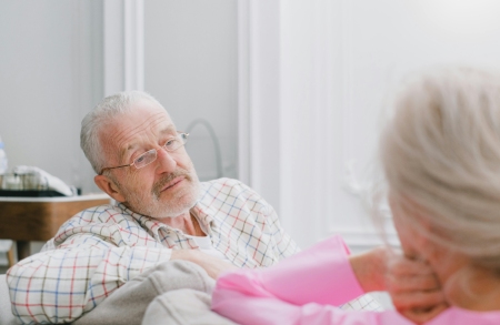 A man talking to another person on the sofa